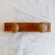 Vintage wooden coat rack with two round hooks.