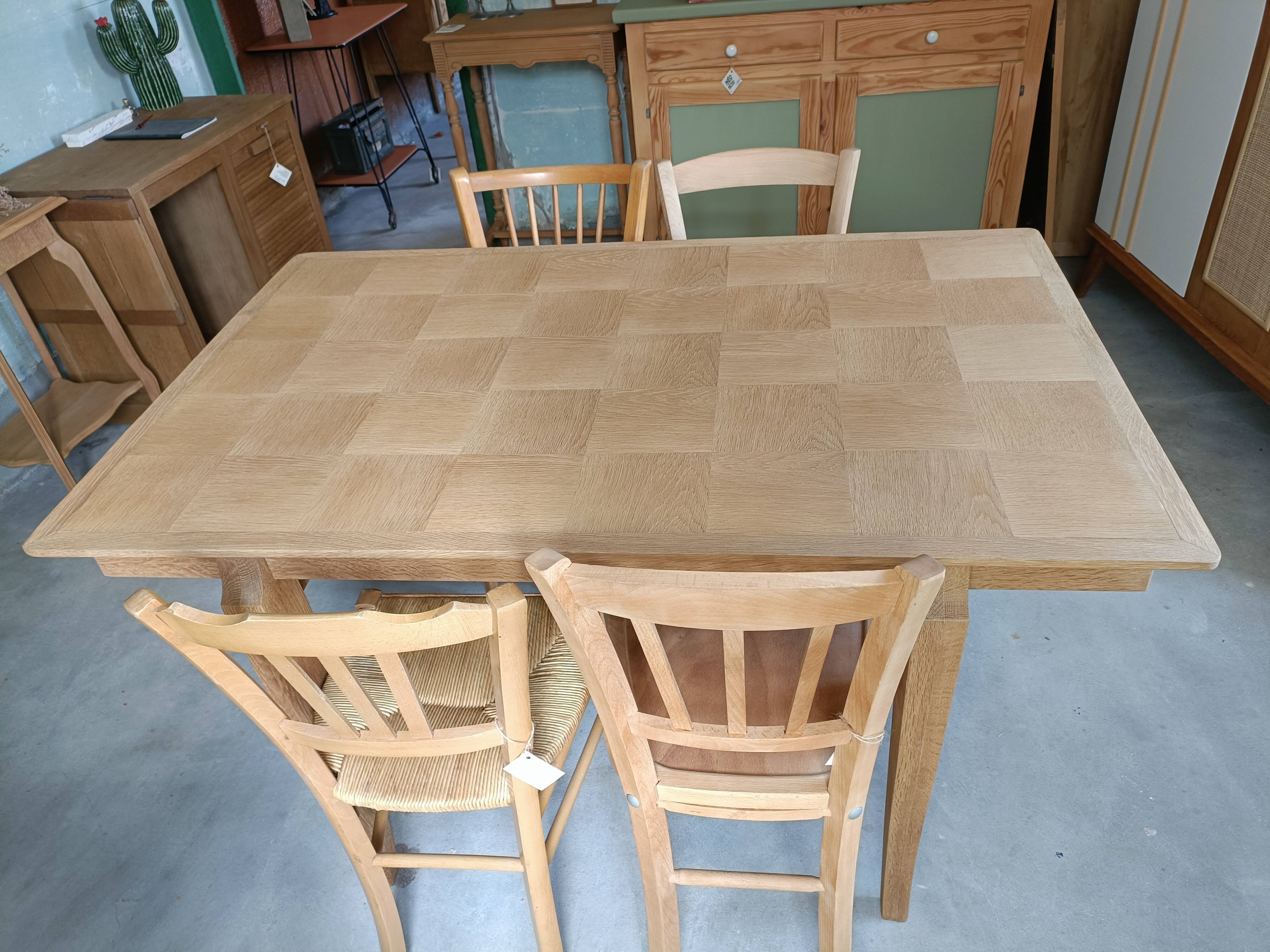 Oak dining table with a checkerboard top and extensions.