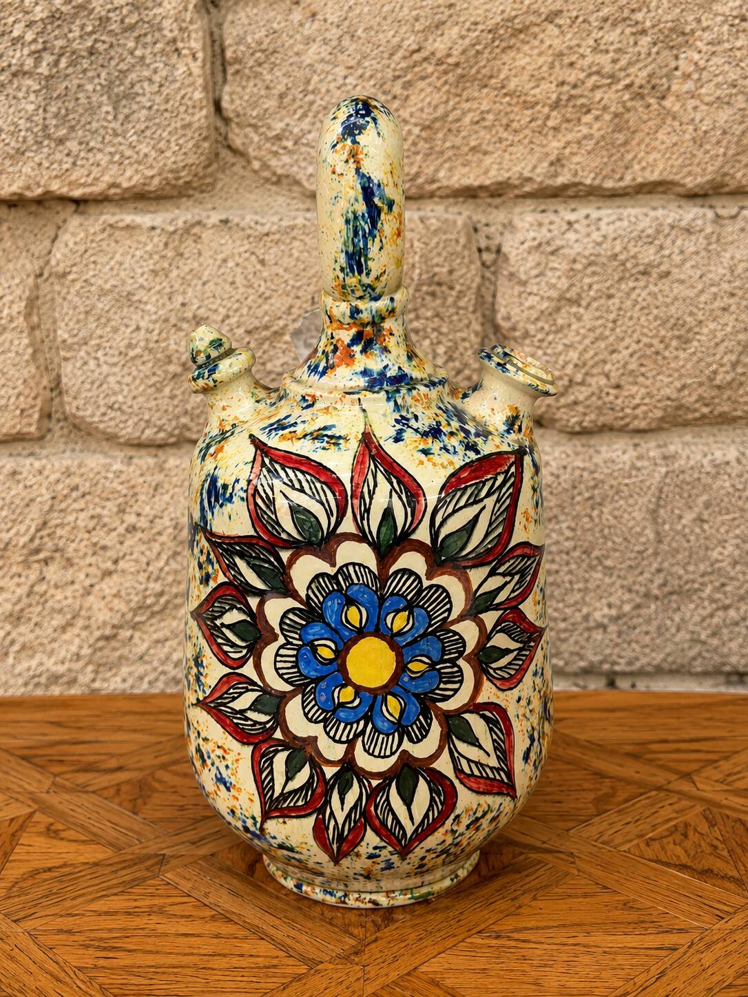 polychrome floral-decorated jug in glazed ceramic