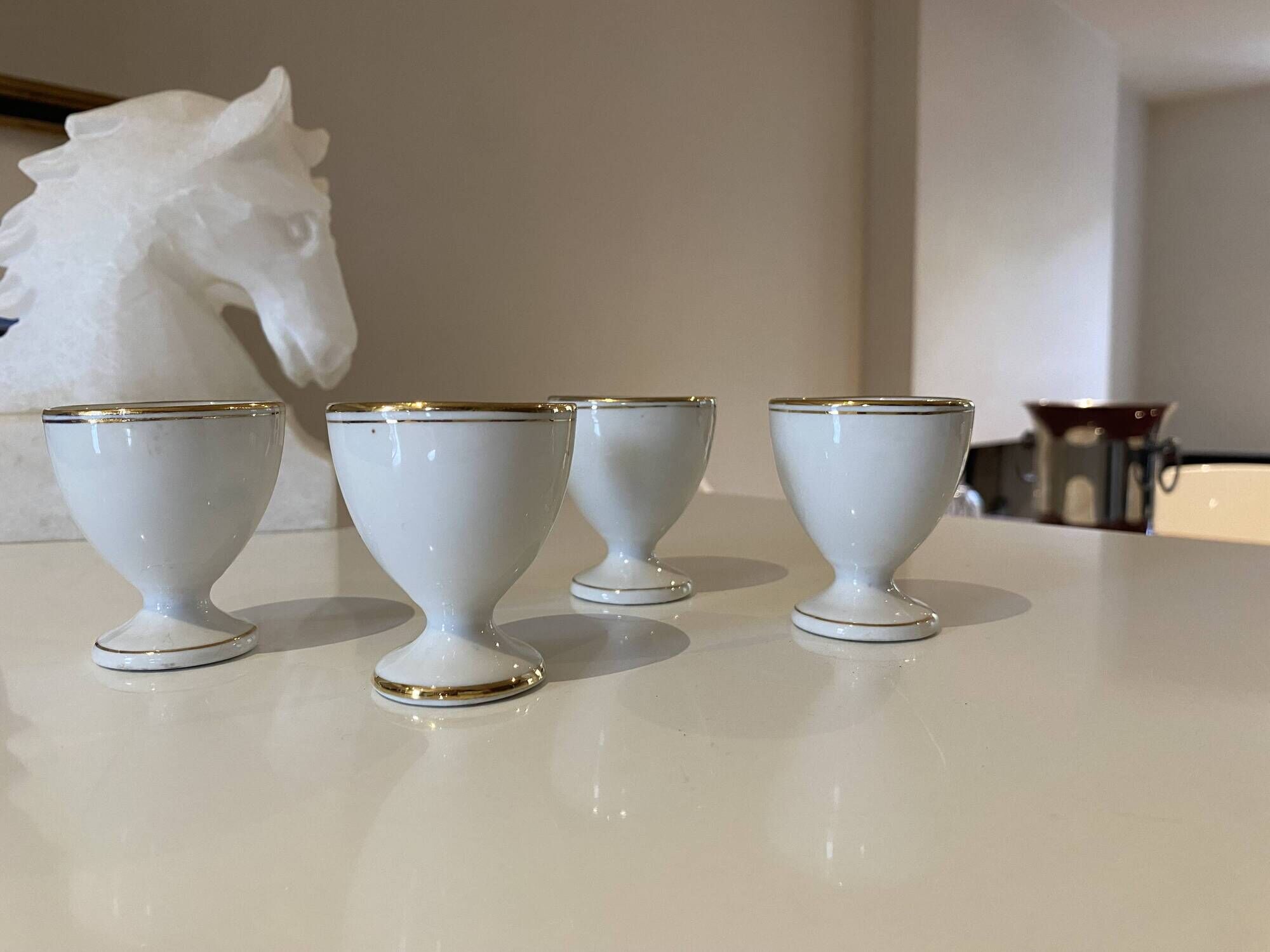 Set of 4 vintage egg cups in white porcelain with a gold rim.