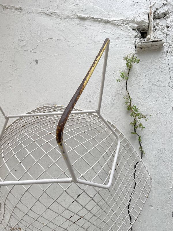 Paire de fauteuils en métal grillagé patiné blanc.