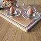 2 egg cups with matching glass cloches in transparent glass