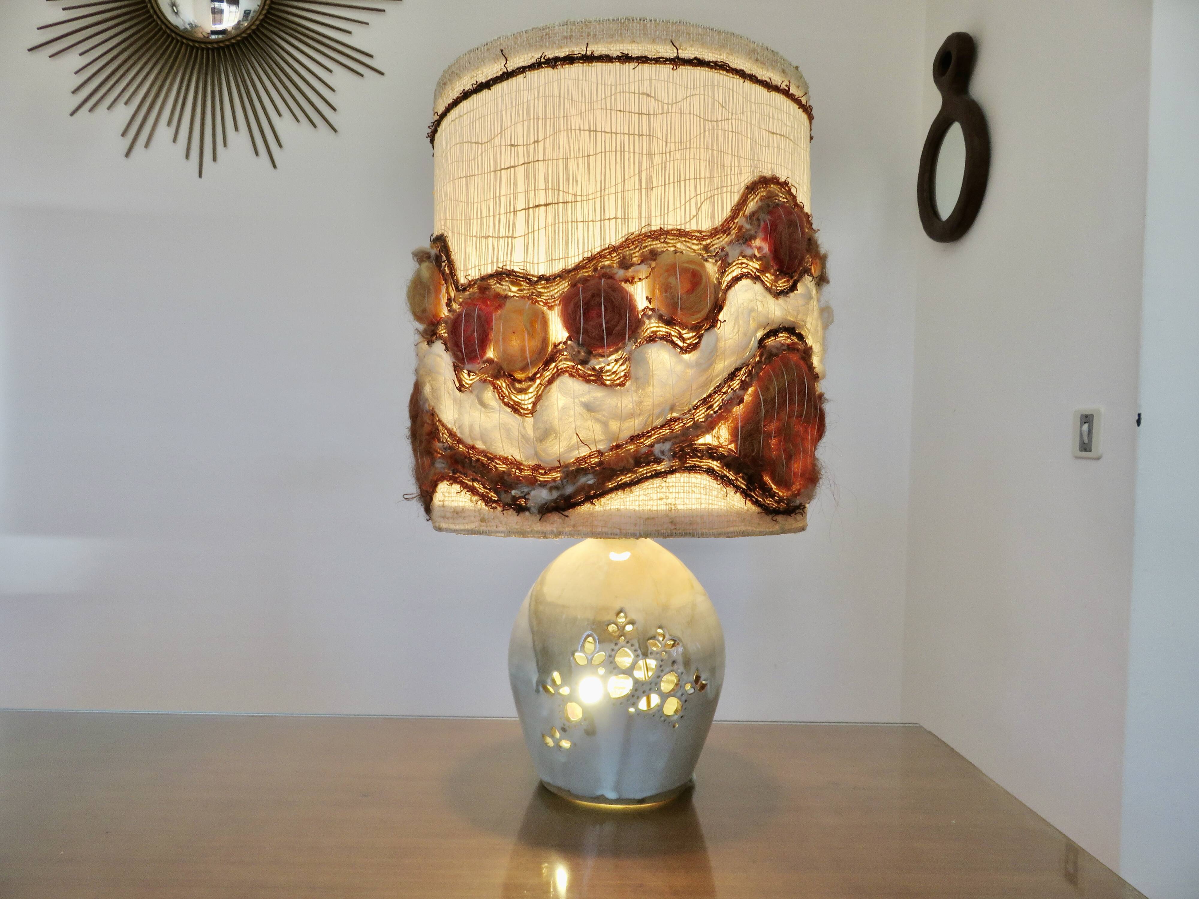 Ceramic lamp with double lighting and openwork design.
