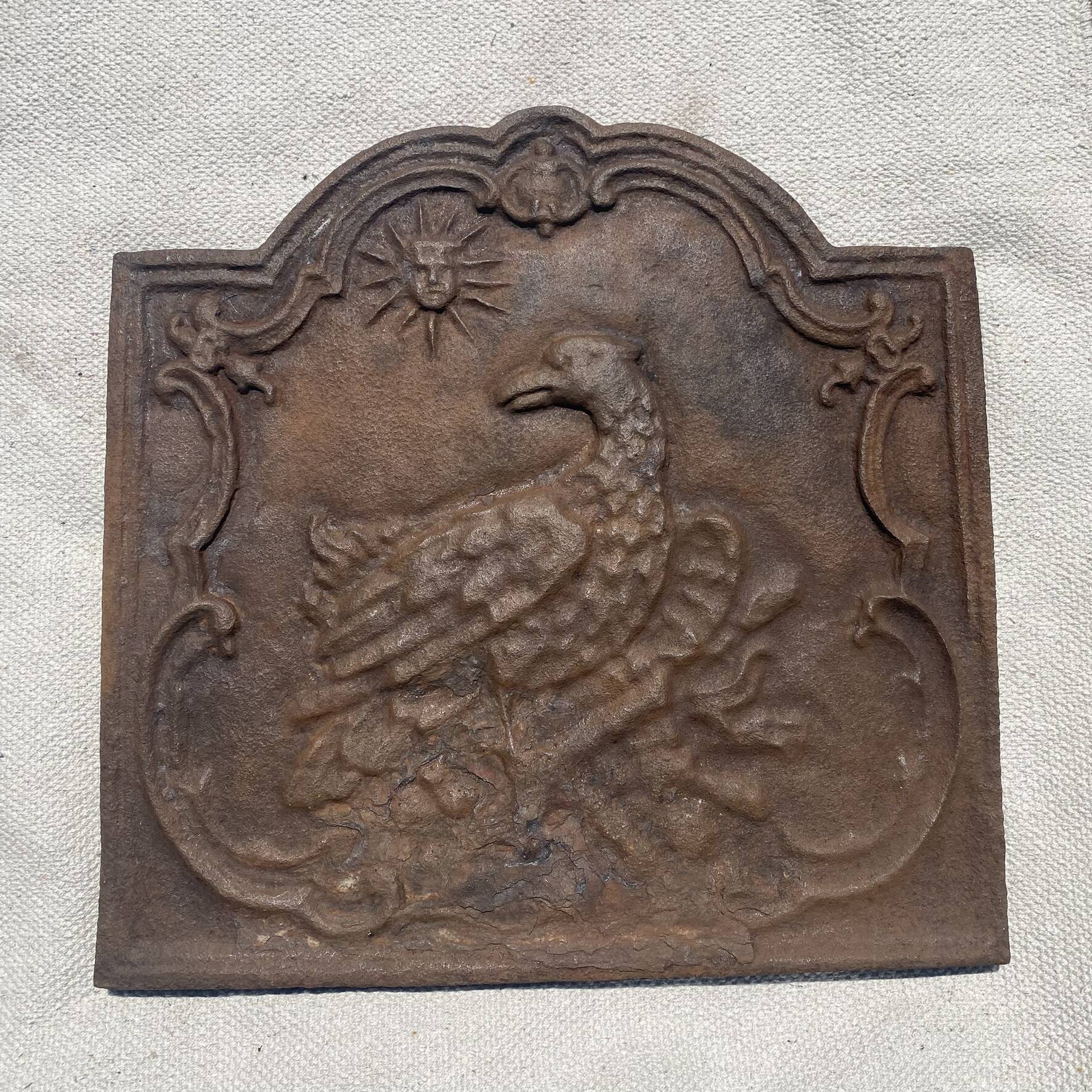 Ancienne plaque de cheminée en fonte ,décor aigle et soleil, 47 × 47 cm