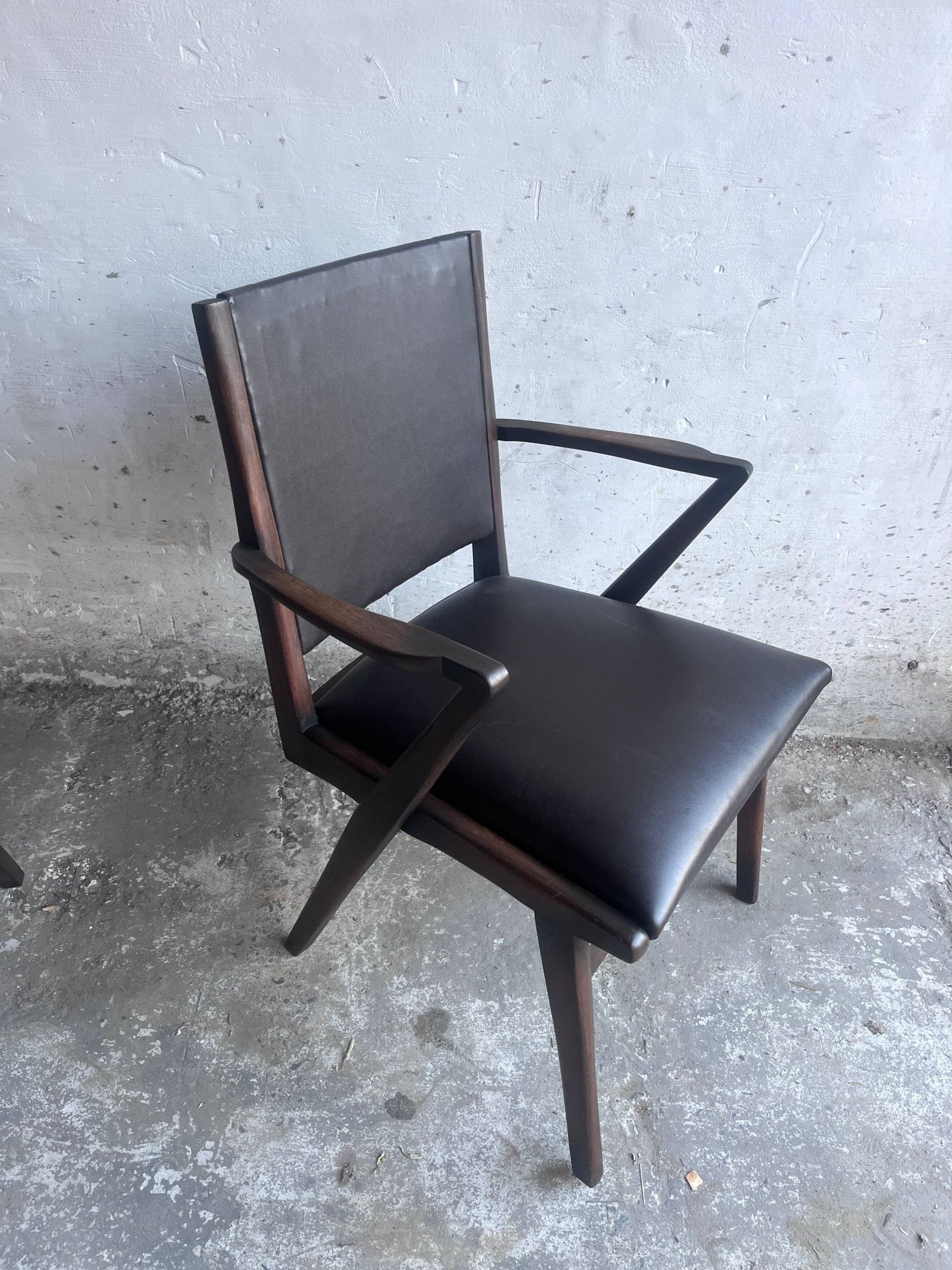 Pair of sculptural mid-century armchairs in dark wood and brown upholstery.
