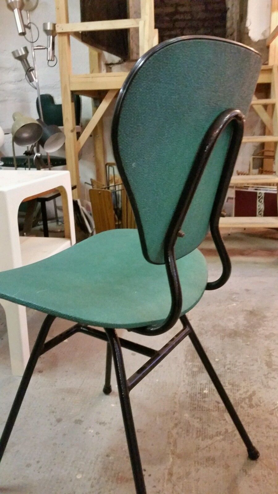 Chair in curved wood covered with vinyl, metal tube.