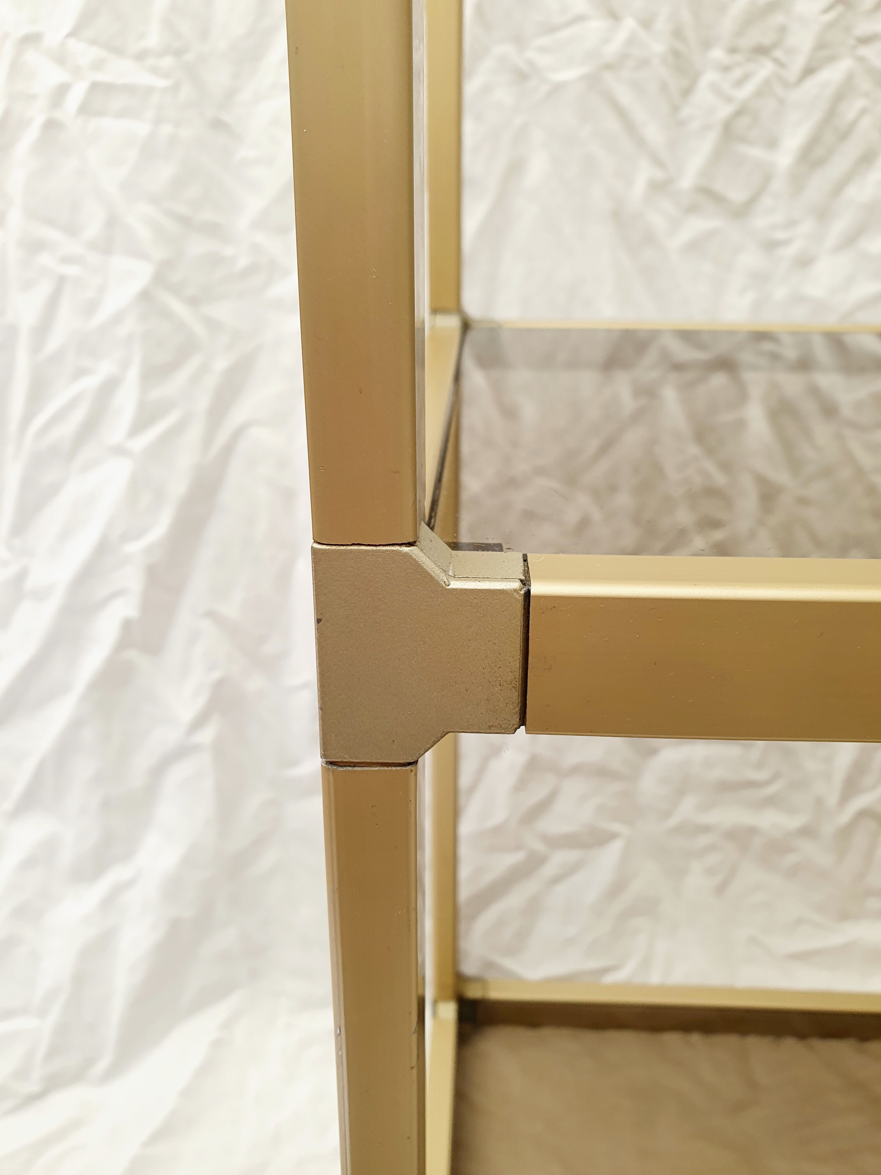 Golden metal shelf and smoked glass