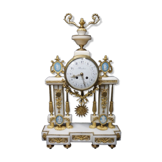 A beautiful white marble portal table clock with gilding ornaments at the fire.