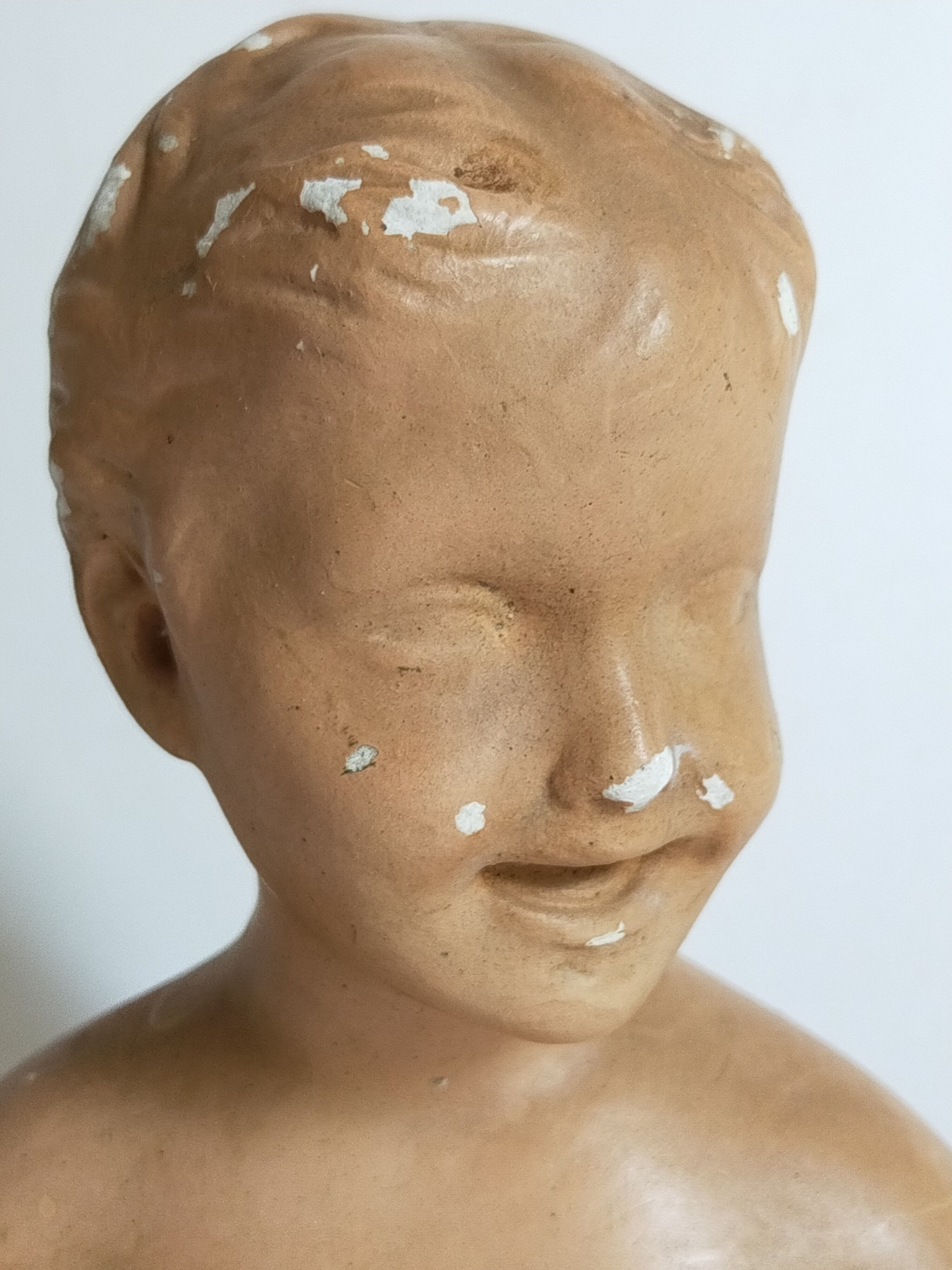 Bust of a small child in ancient plaster