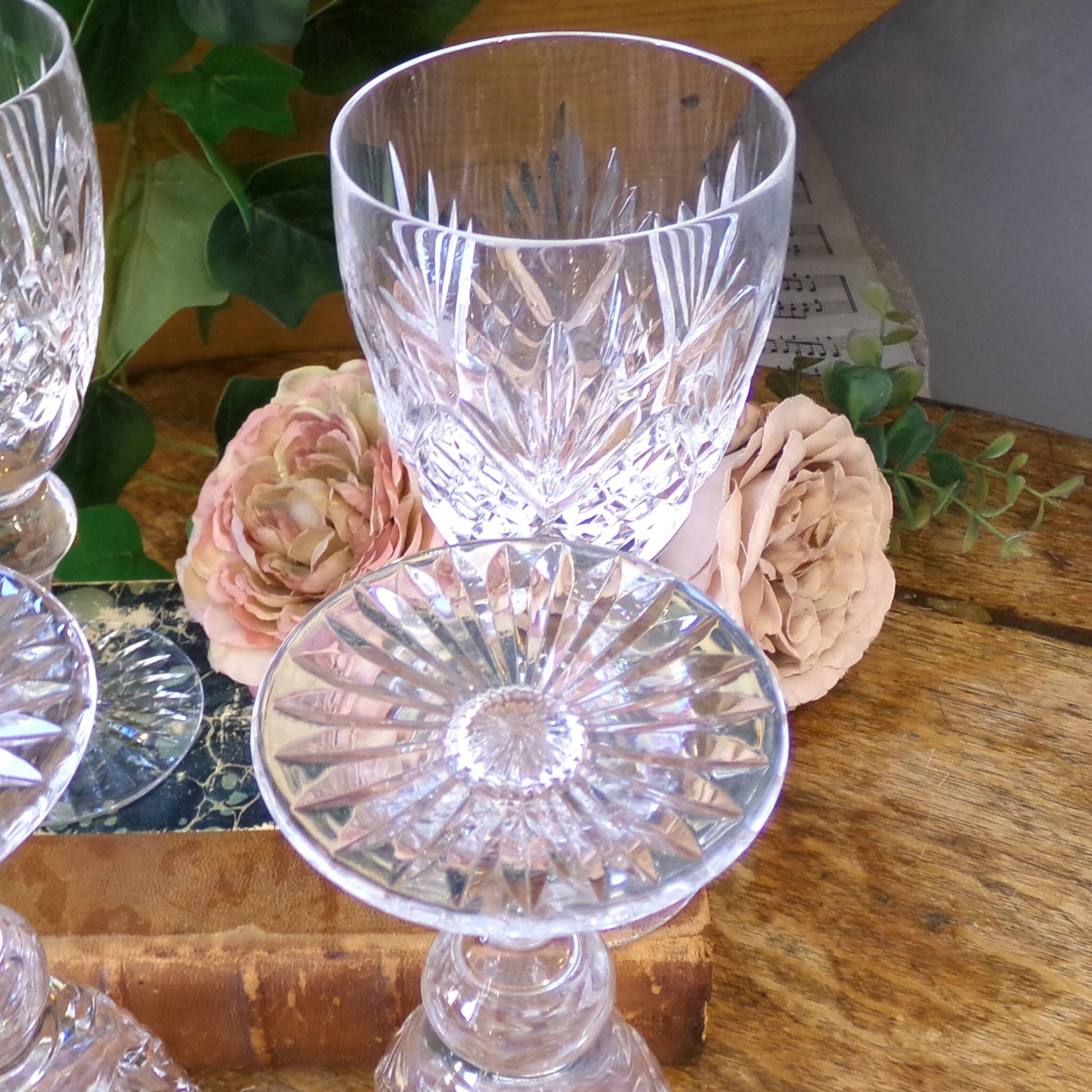 Cut crystal white wine glasses with a slender baluster-shaped stem.
