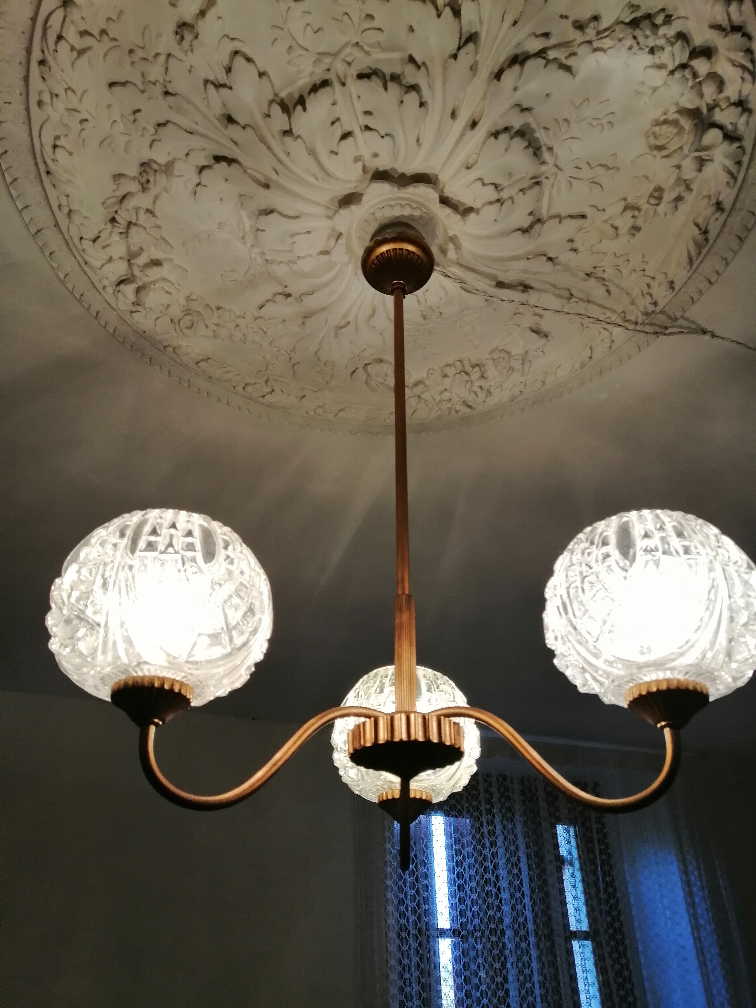 antique chandelier has 3 globes