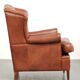 Light cognac-coloured cow leather wingback armchair with matching piping