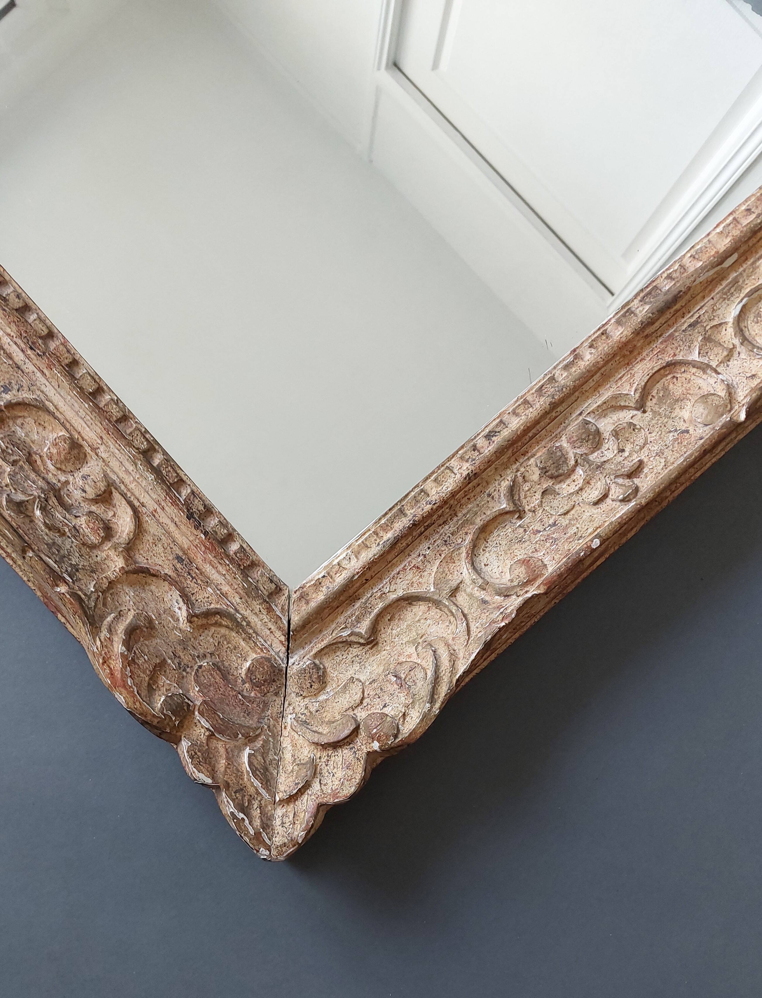 Large Montparnasse rocaille style frame in carved wood mounted in mirror.
