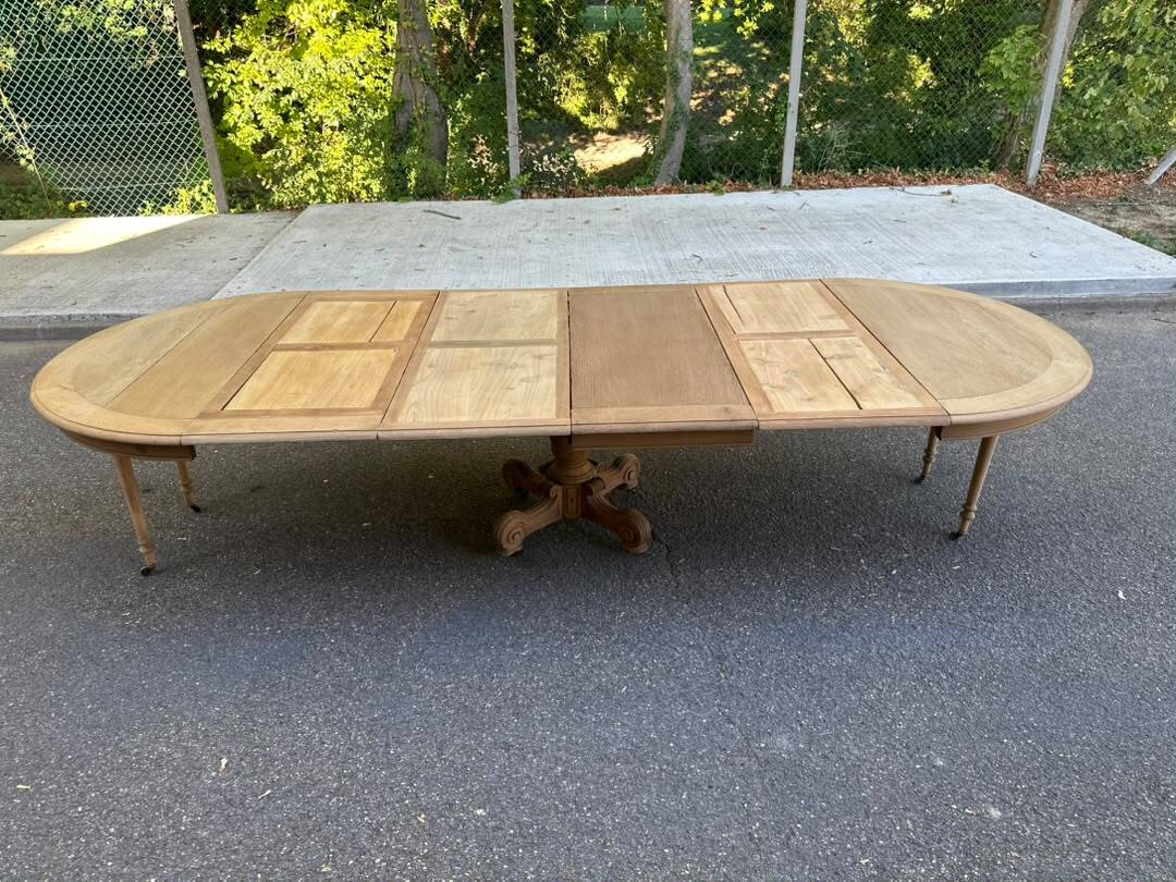 Round dining table with a central pedestal, stripped raw oak, 4 extensions, 19th century.