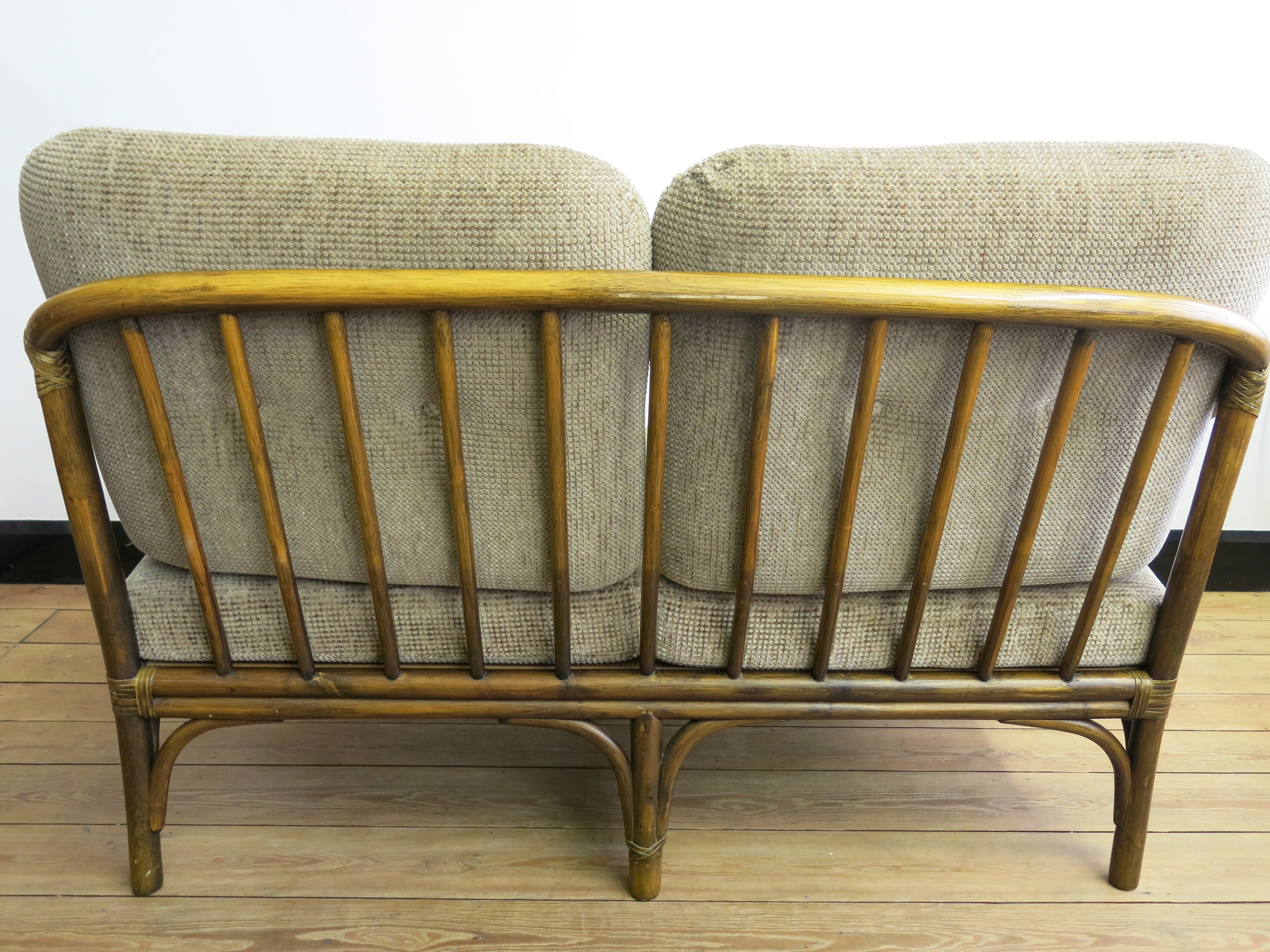 Two-seater rattan sofa with natural tones