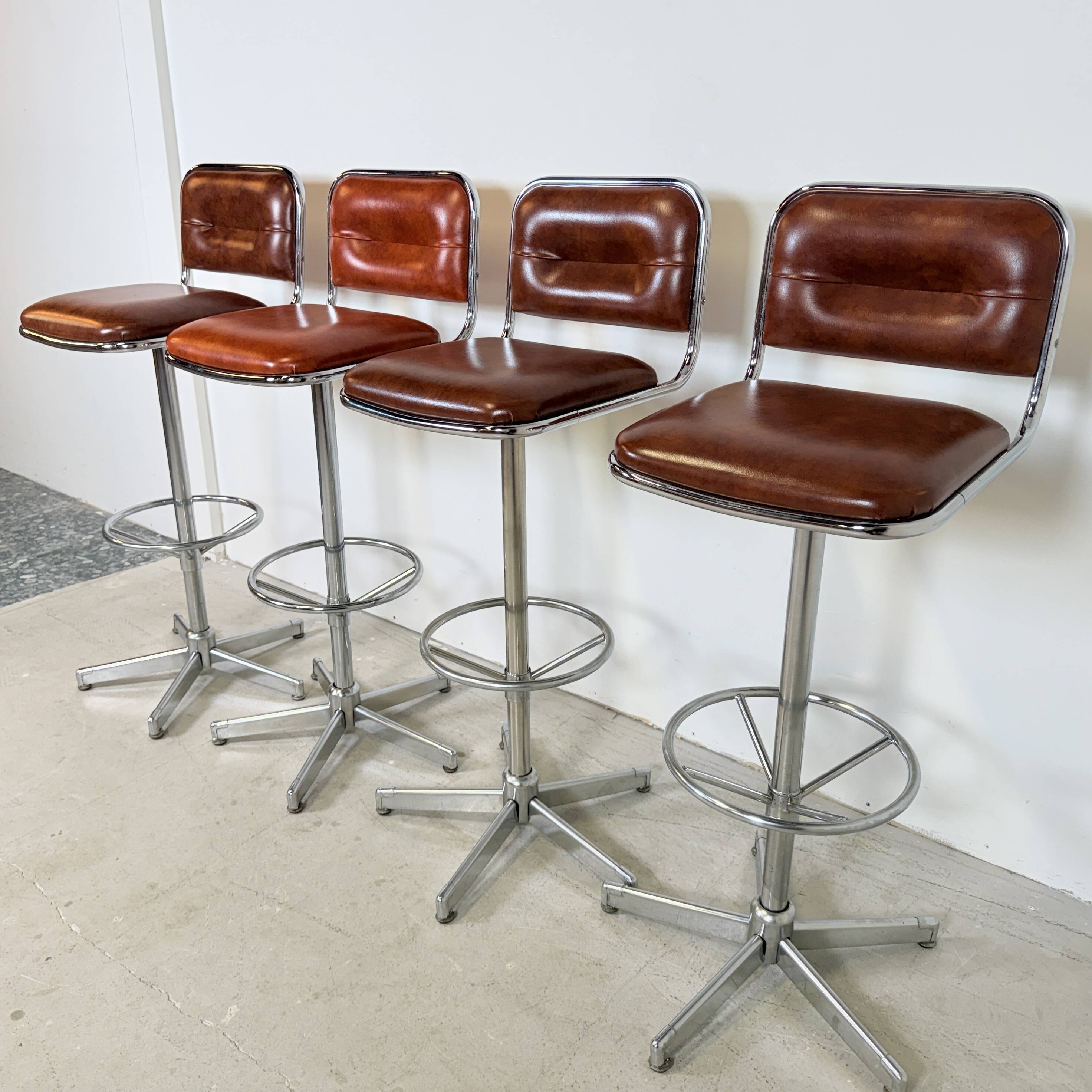 1970s chrome bar stools with cognac-colored faux leather upholstery