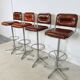 1970s chrome bar stools with cognac-colored faux leather upholstery