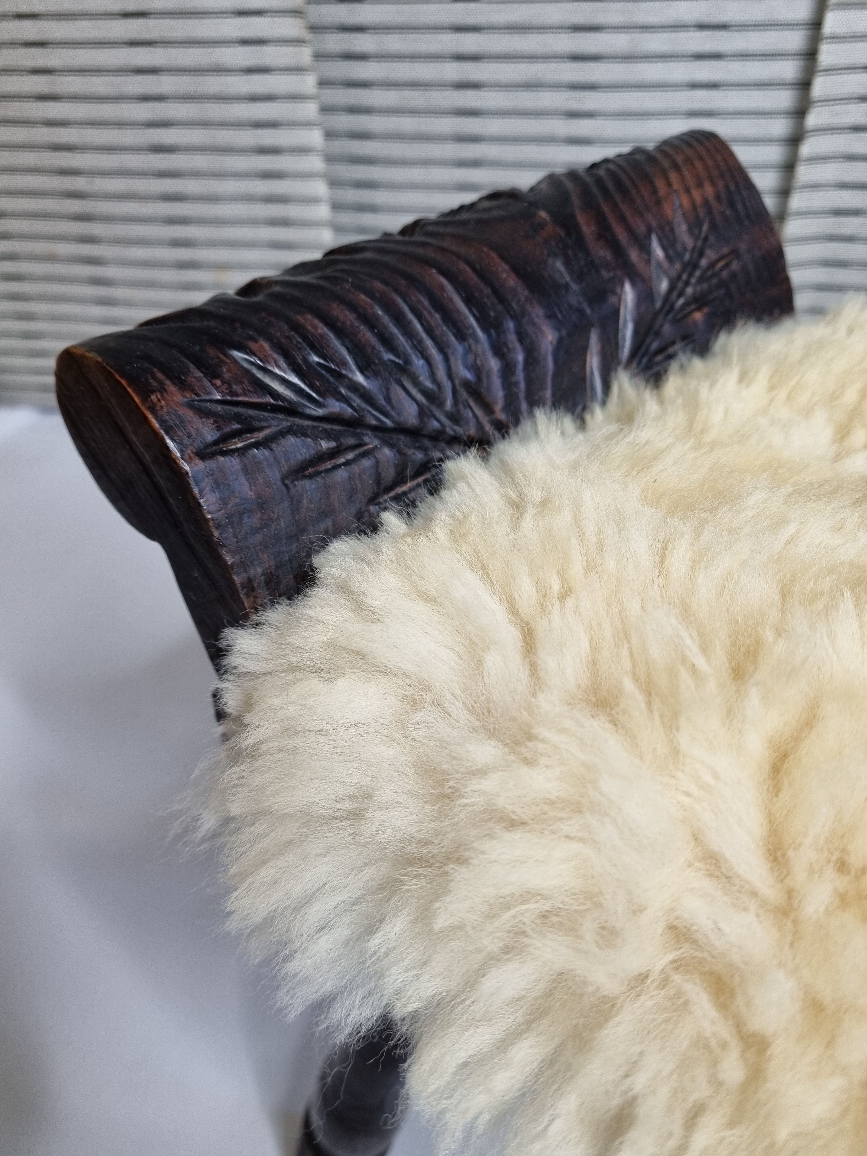 Carved wooden stool covered with Celtic-style sheepskin