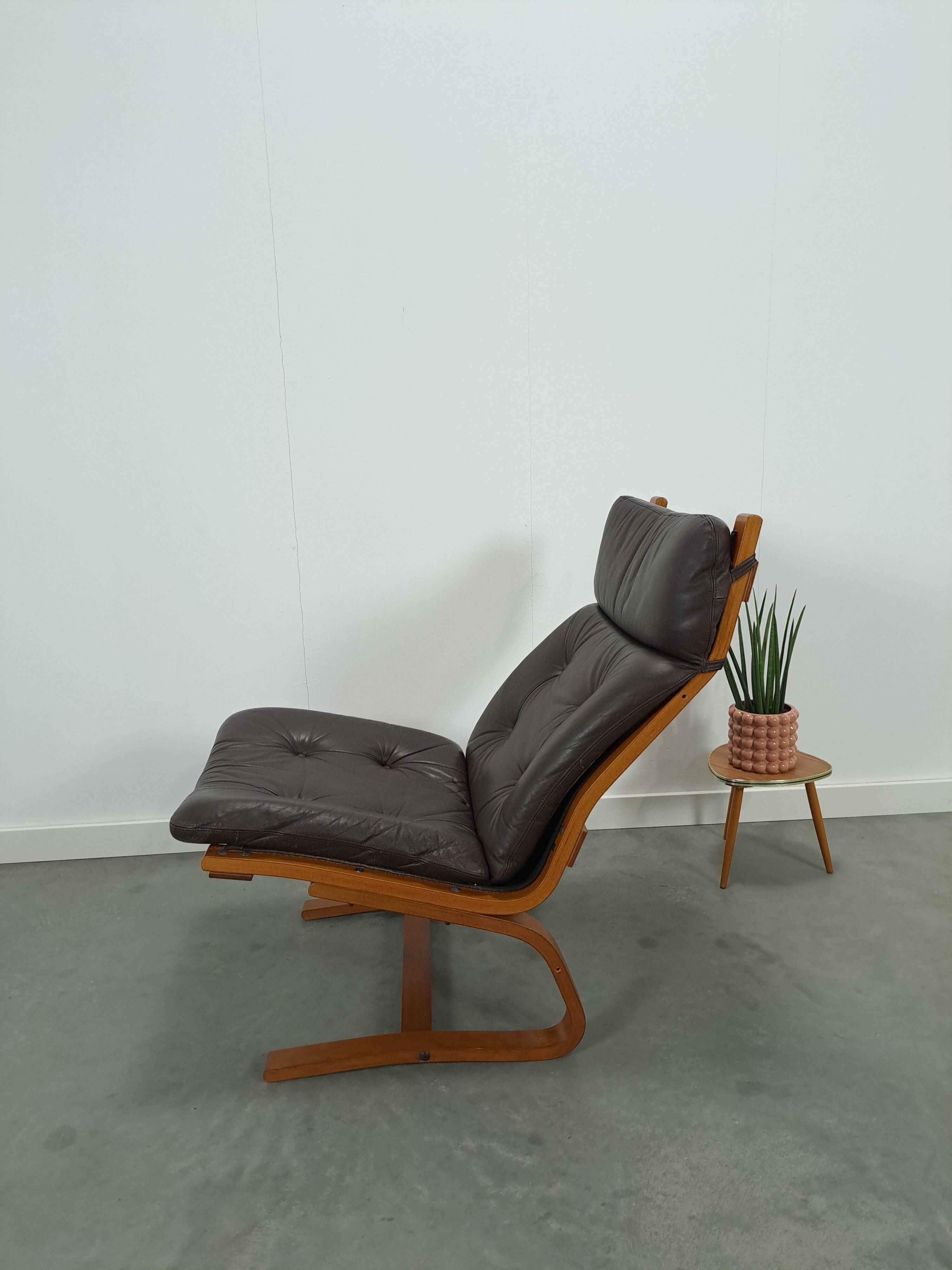 Bruin leren fauteuil met houten onderstel