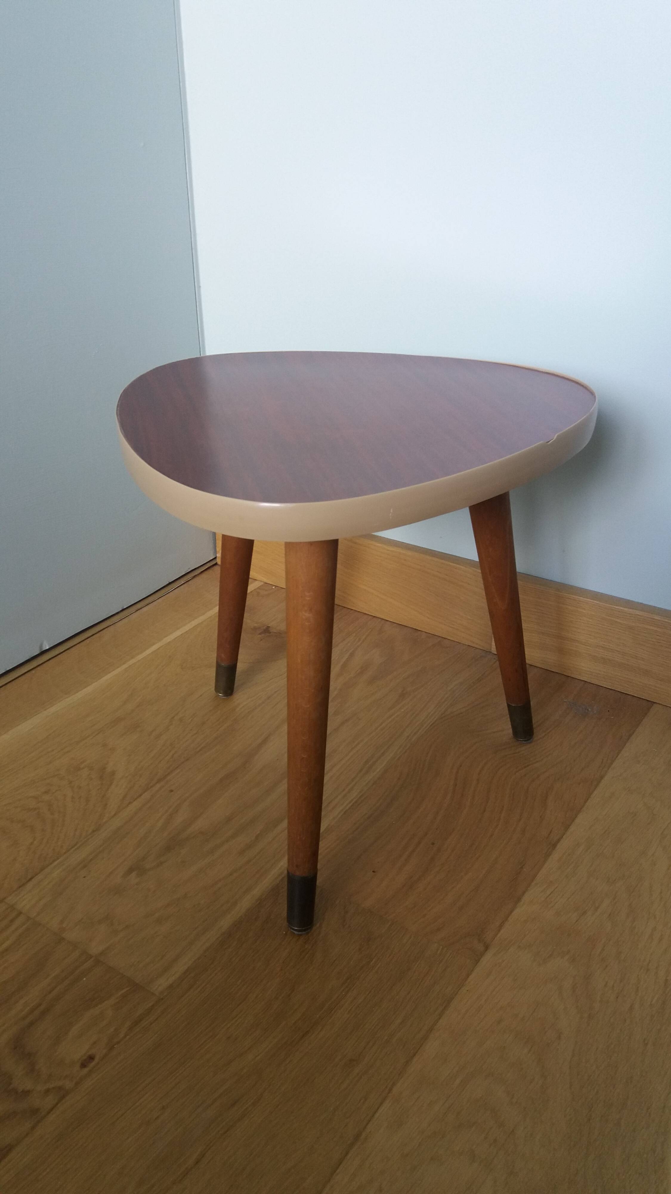 Tripod console table plant stand in the shape of a plectrum.