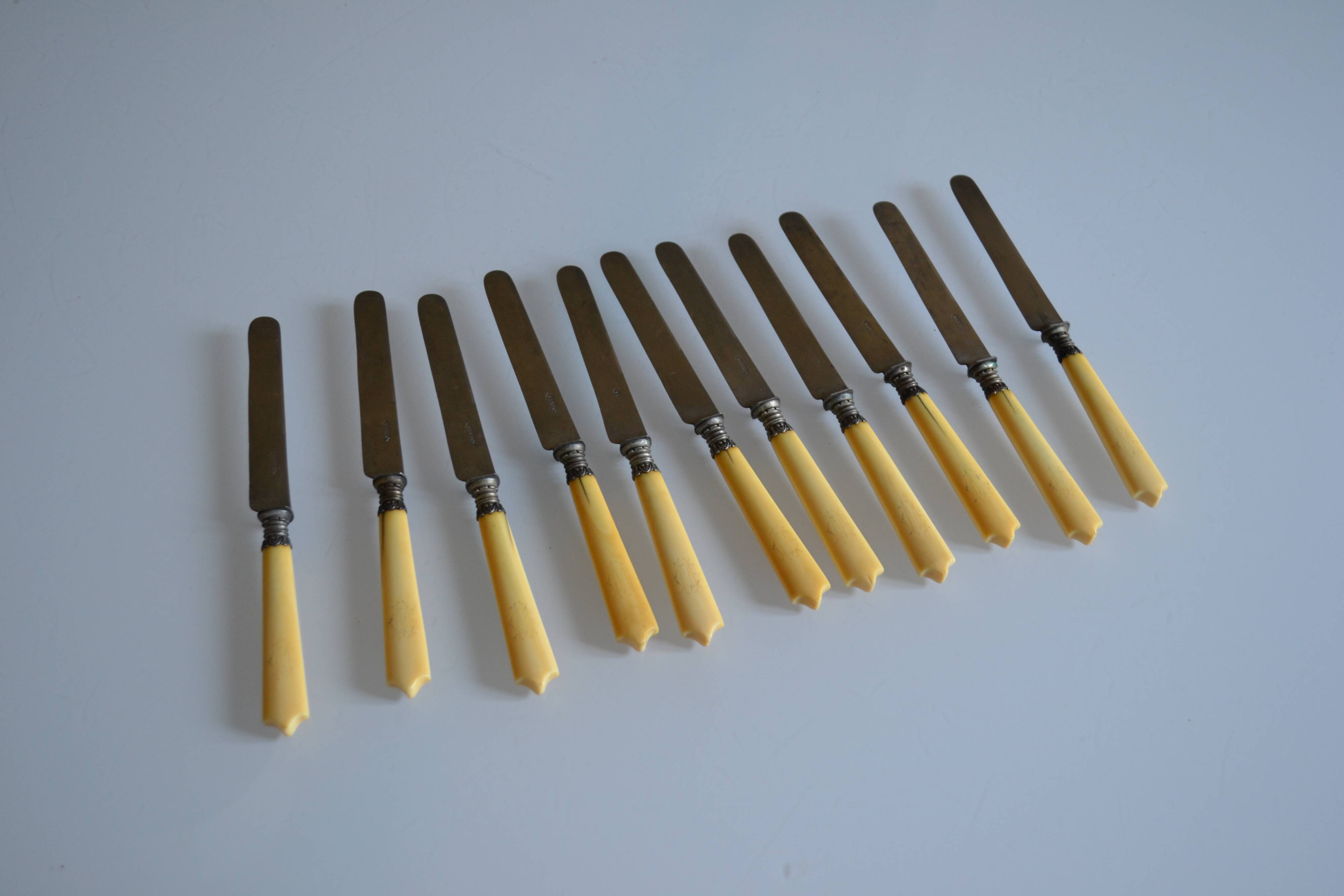 11 antique 19th-century table knives with ivory-colored monogram handles