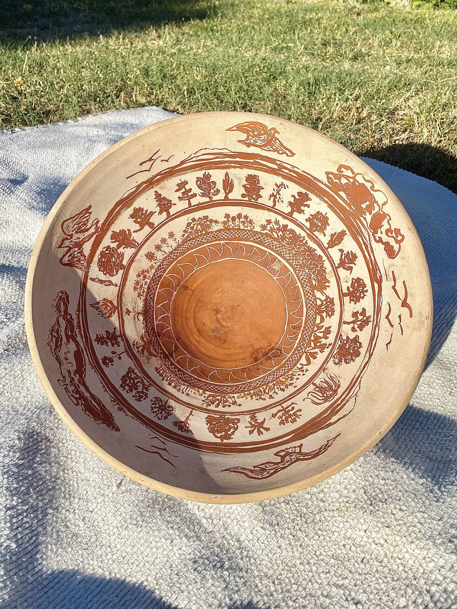 Large shallow terracotta dish decorated with birds, 20th century.