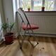 Vintage folding chair in red faux leather with a chrome frame.