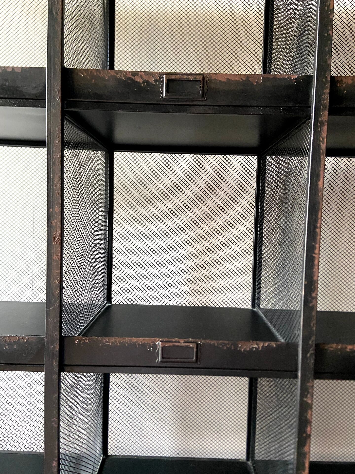 Black metal shelf with compartments.