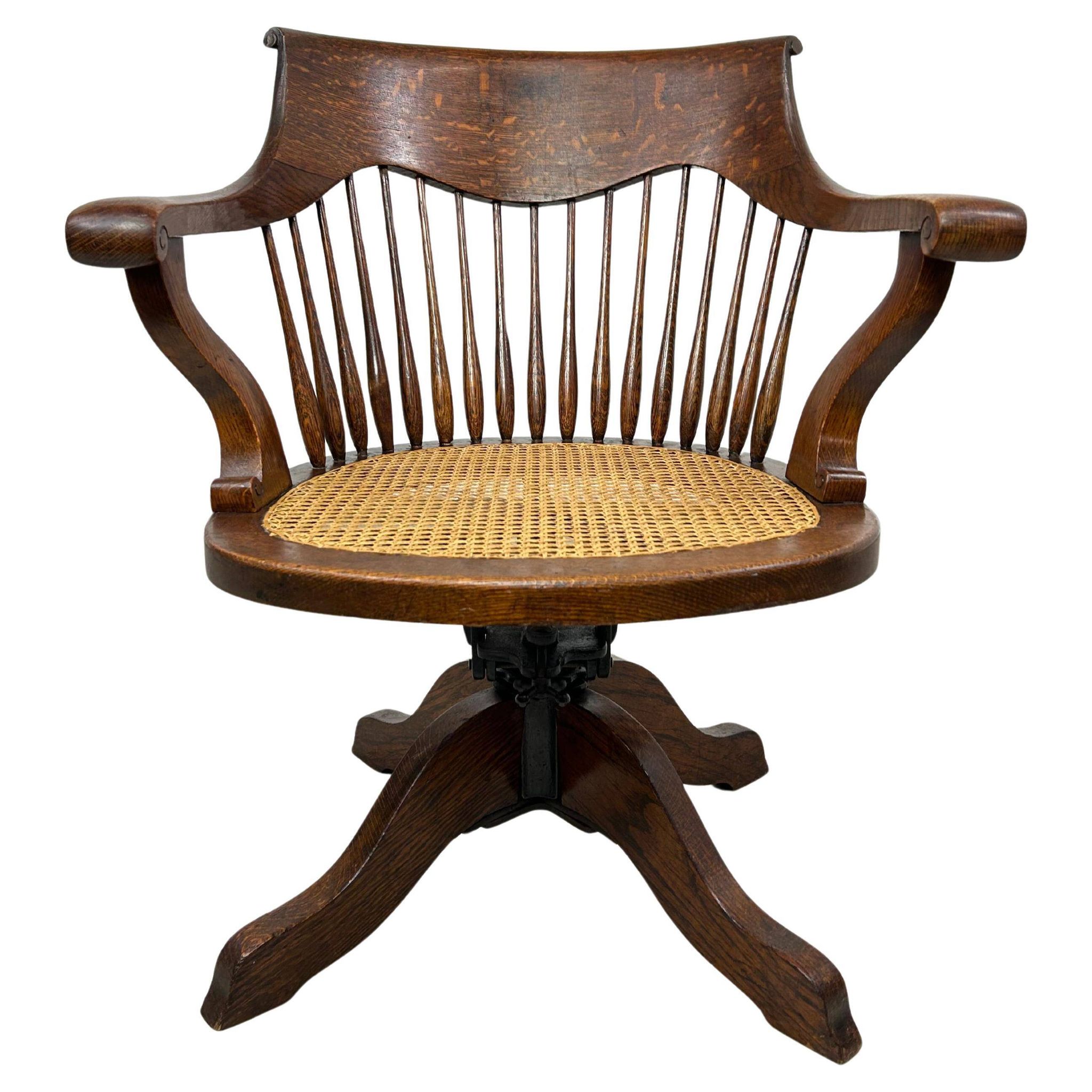 Swivel office chair in oak with a rattan seat.