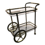 Two-tier bar cart in gold-plated brass with transparent glass shelves, yellow finish.