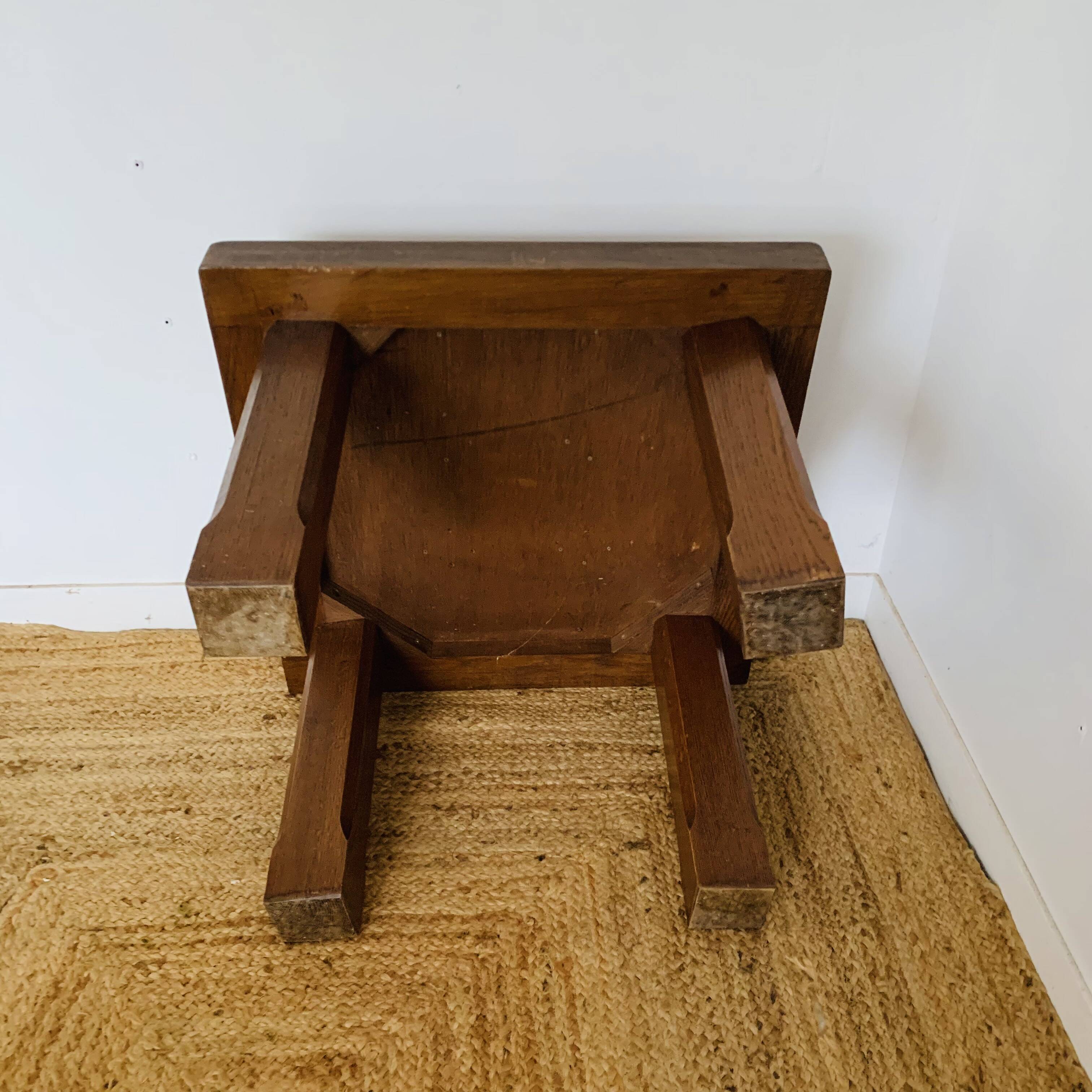 Square table with red tiles signed.
