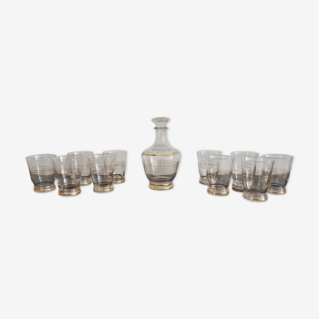 Old glass liquor service and golden border with its decanter and 10 vintage glasses