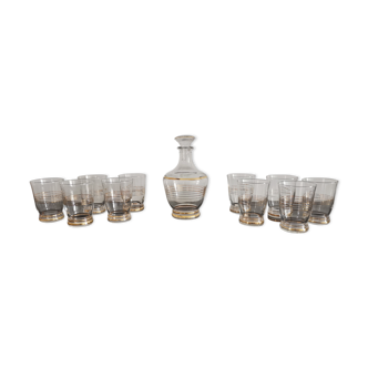 Old glass liquor service and golden border with its decanter and 10 vintage glasses