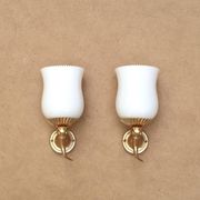 Pair of gold metal and opaque glass wall lights adorned with fish from the 1950s.