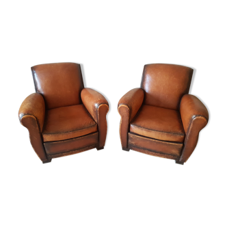 Pair of patinated and worn cognac leather club chair