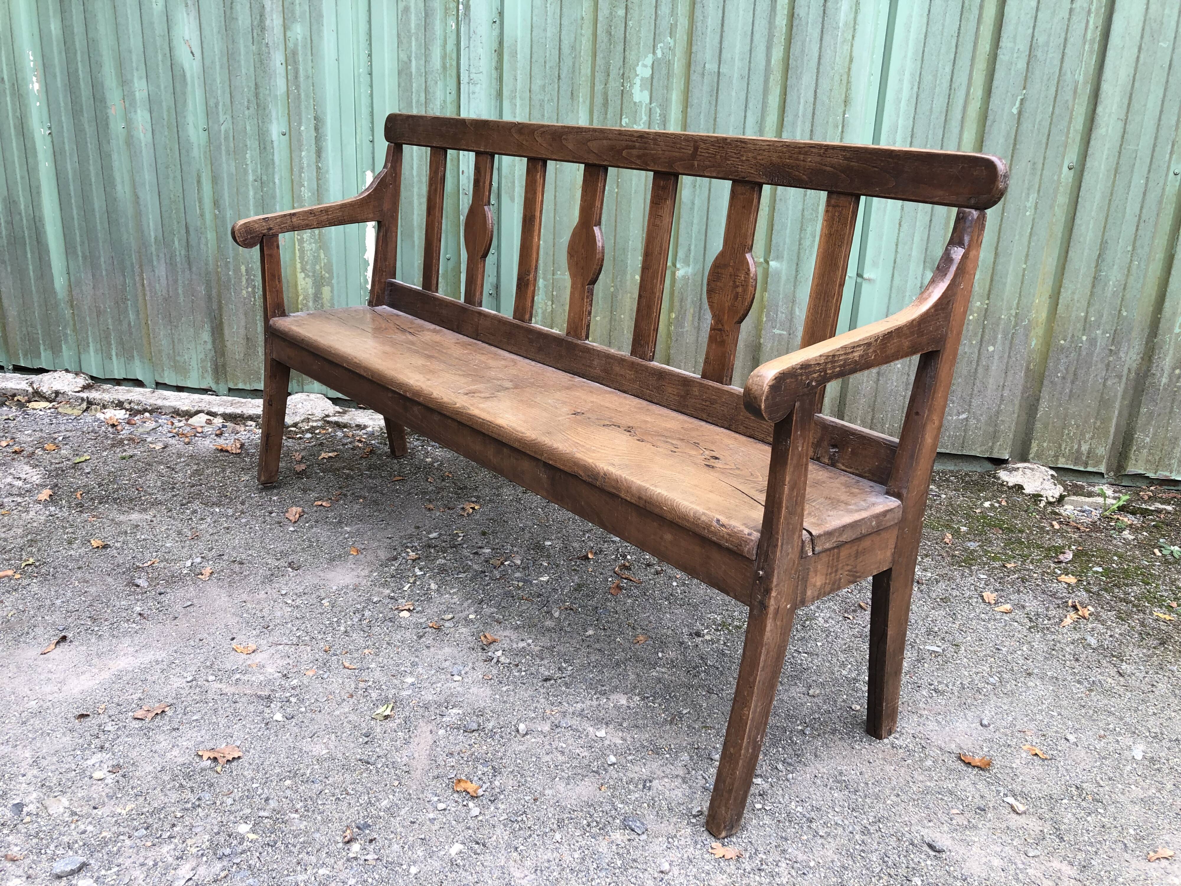 Duo of old solid oak benches with backs and armrests.