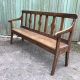 Duo of old solid oak benches with backs and armrests.