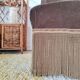 Brown velvet crapaud armchair with fringes and sculpted legs.