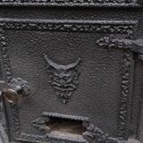 Black cast iron wood burning stove with solid brass handle.