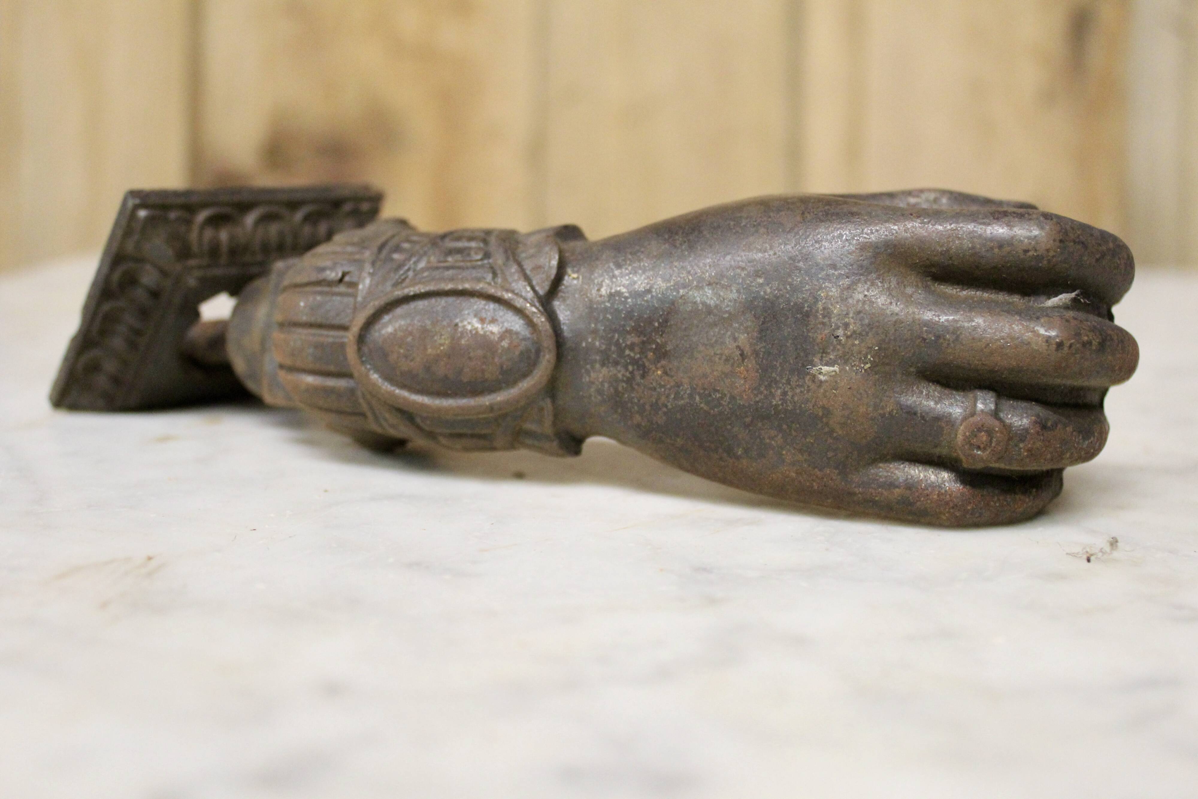Antique cast iron door knocker in the shape of a 19th century hand