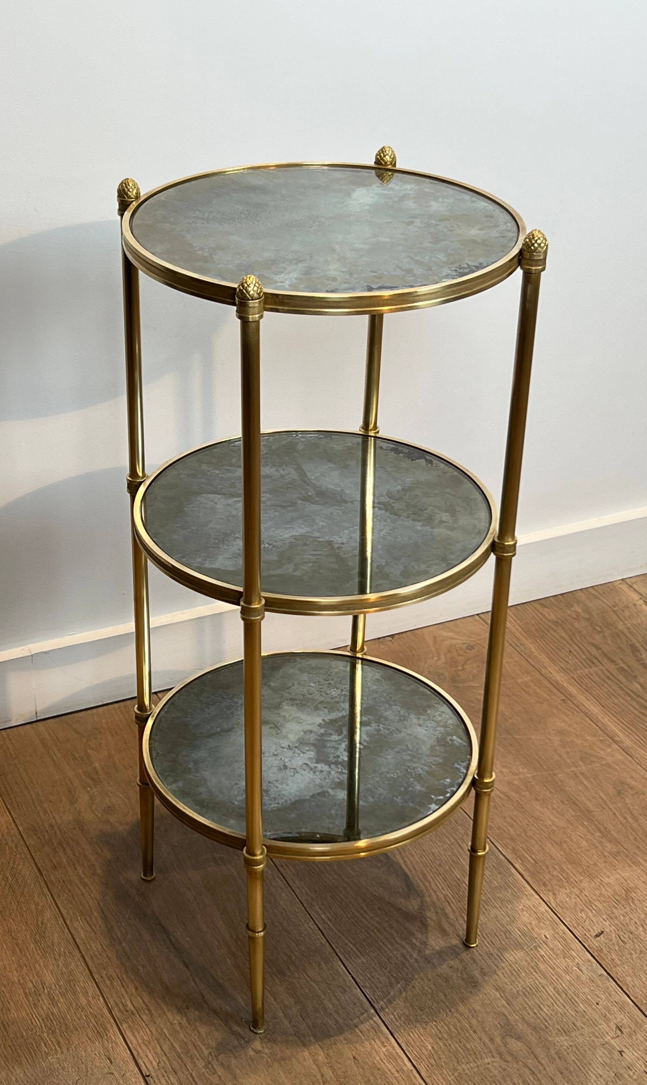 Round bronze side table with triple shelves of églomisé mirrors from Maison Baguès