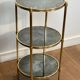 Round bronze side table with triple shelves of églomisé mirrors from Maison Baguès