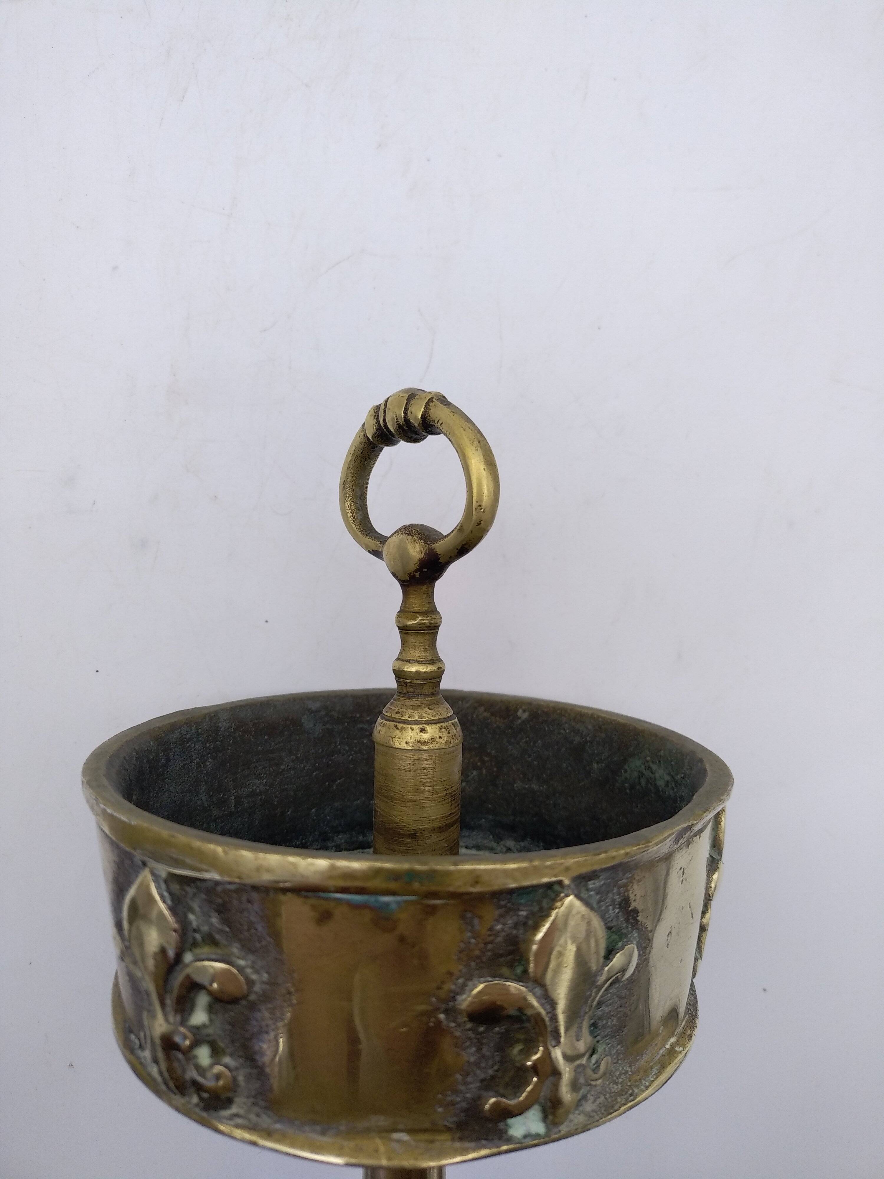 Ashtray on foot. Bronze and brass, with fleur-de-lis decoration.