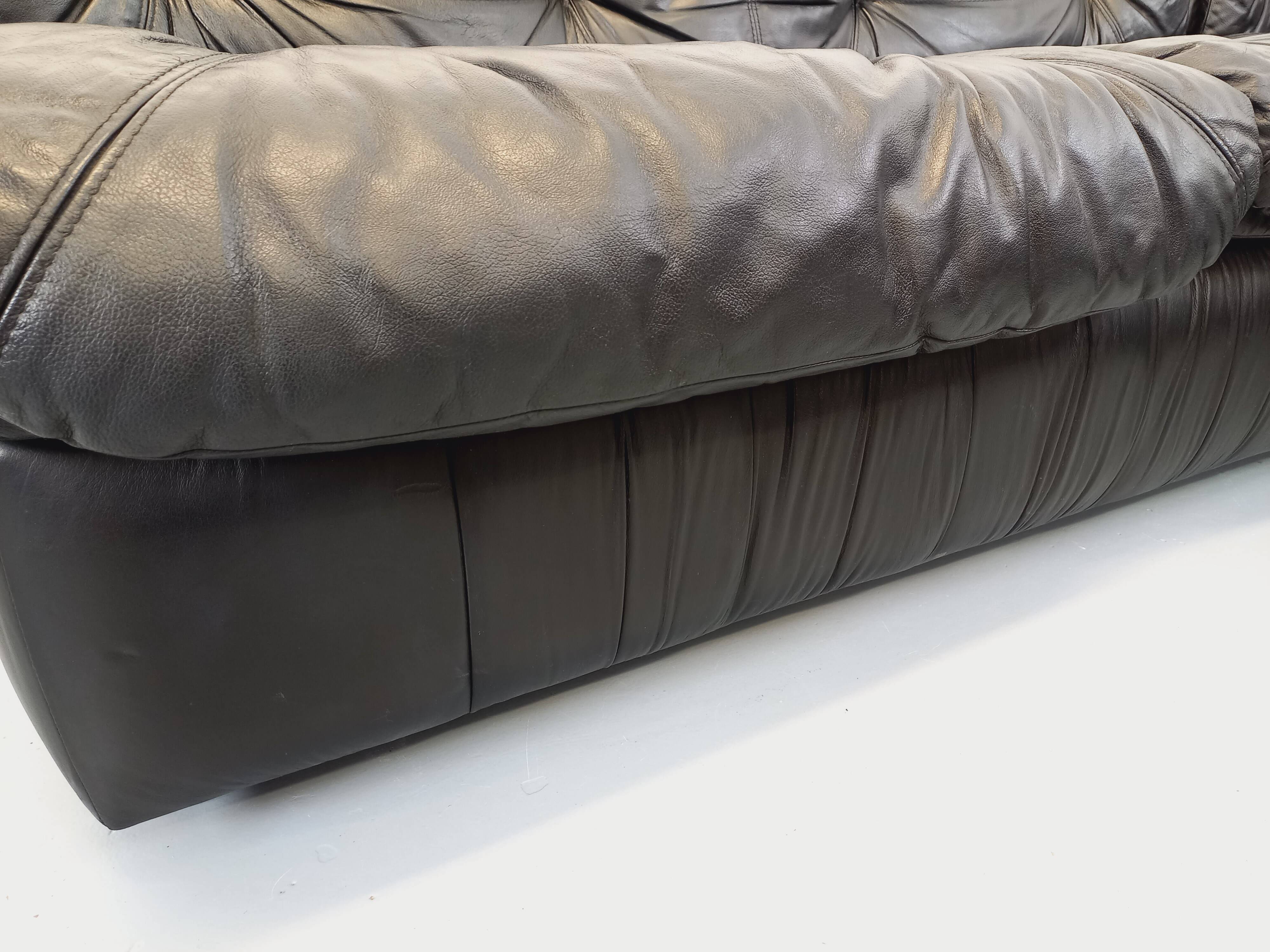 Vintage corner sofa composed of 3 modules in black leather with integrated bed.