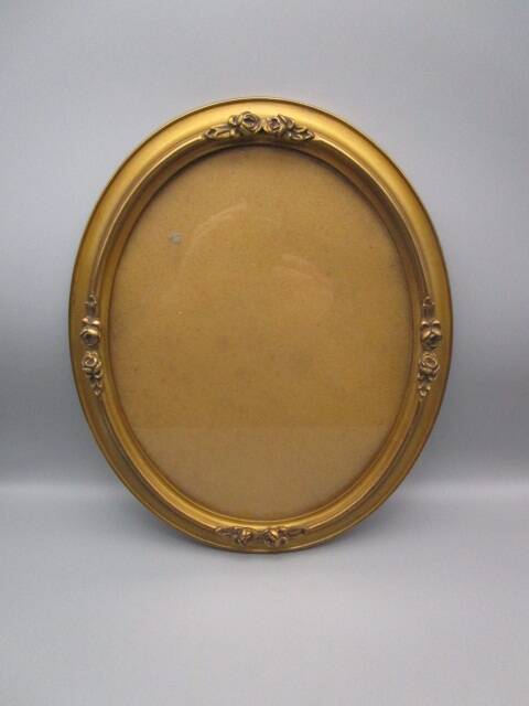 Old oval frame in wood and gilded stucco
