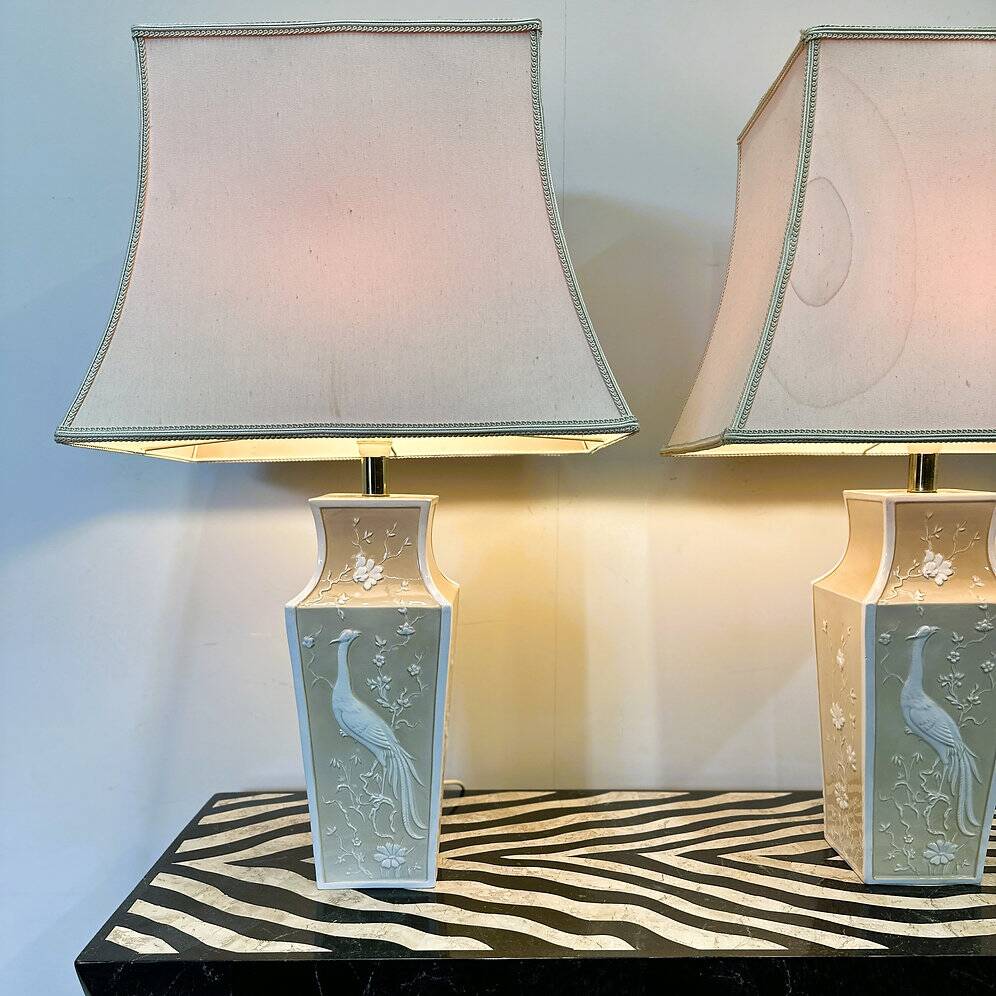 Pair of large cream ceramic table lamps with relief peacocks and fabric shades