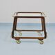 May include: A mid-century modern bar cart with a dark wood frame and two c