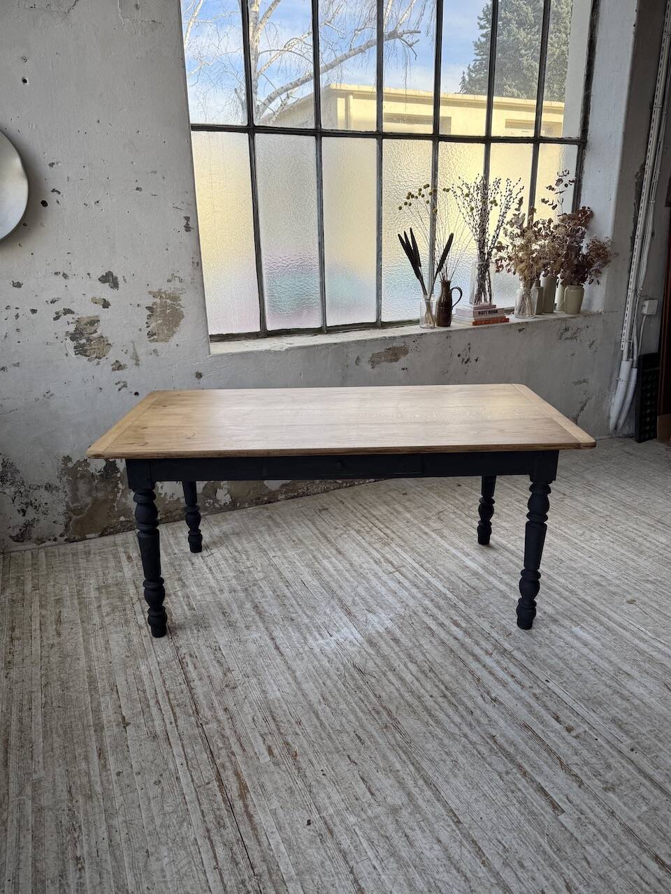 Oak farmhouse table with turned black legs.