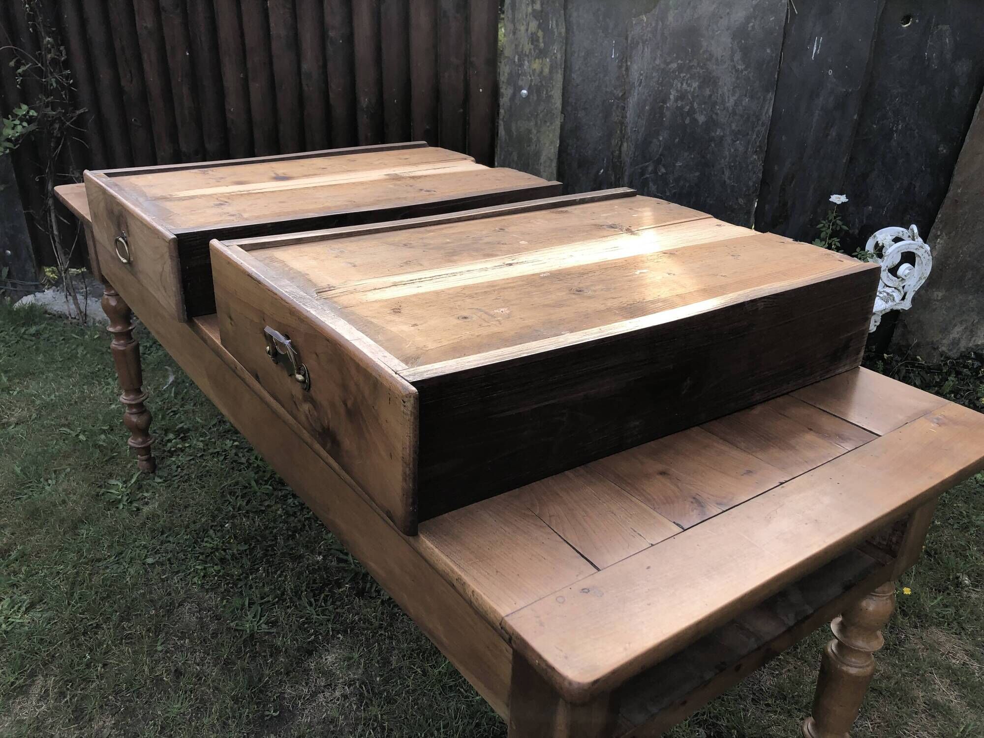 Antique farmhouse table in solid cherry wood with 2 drawers and 1 pull-out at the end with turned legs.