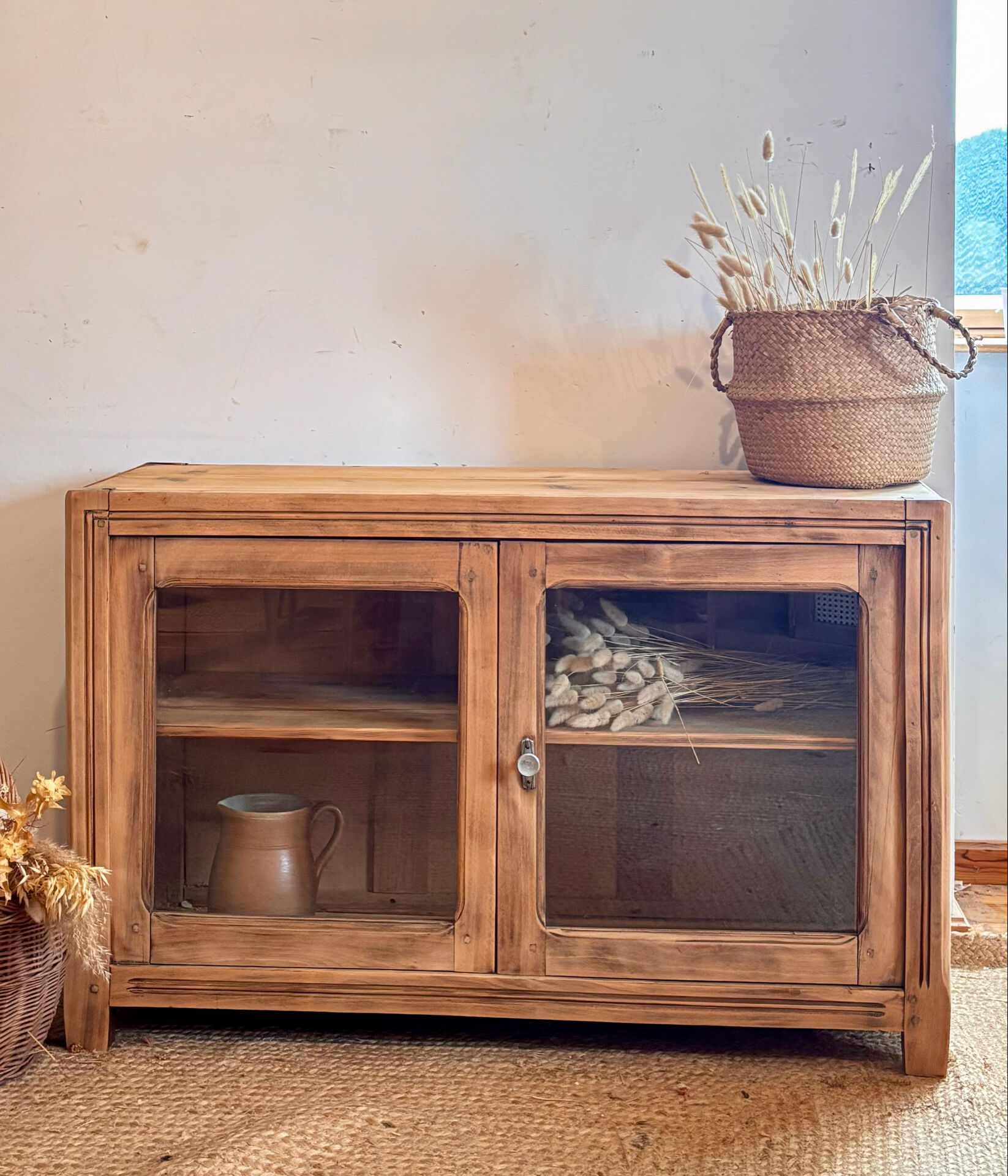 Old wooden buffet with a glass front in raw wood
